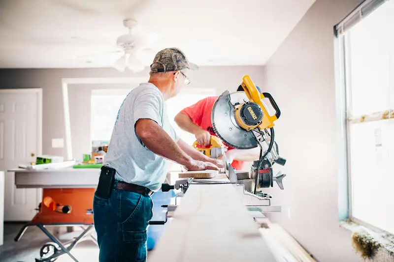 Craftsman cutting trim on a miter saw inside a home